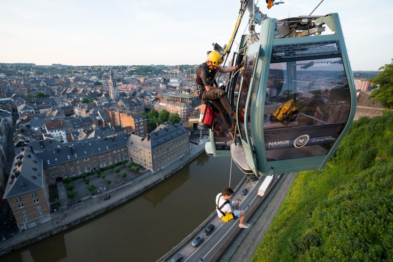 Evakuierung aus einer urbanen Seilbahn. Über ein Rettungsdreieck (Rettungsweste) kann die Person sicher abgeseilt werden (Bild: Namur, Belgien; Petzl).